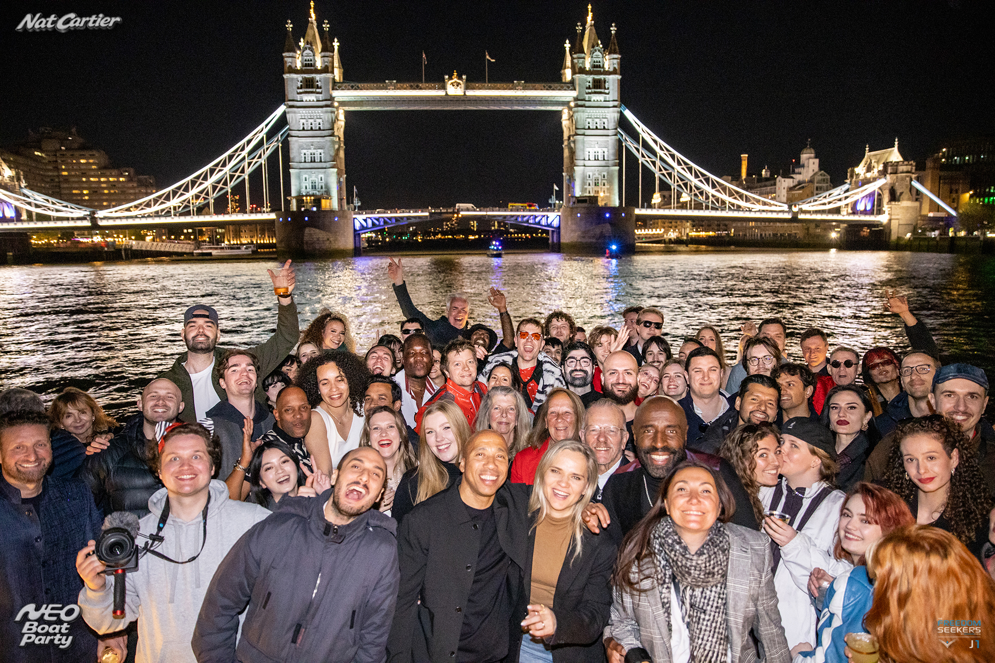 Neo Boat Party guests on the River Thames with Tower Bridge behind